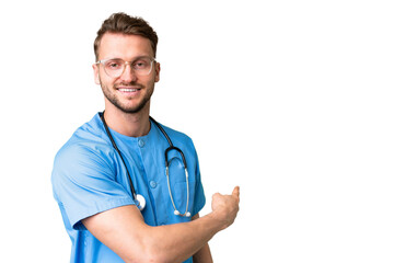Young nurse man over isolated chroma key background pointing back