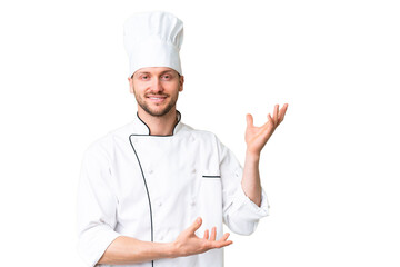 Young caucasian chef over isolated chroma key background extending hands to the side for inviting to come