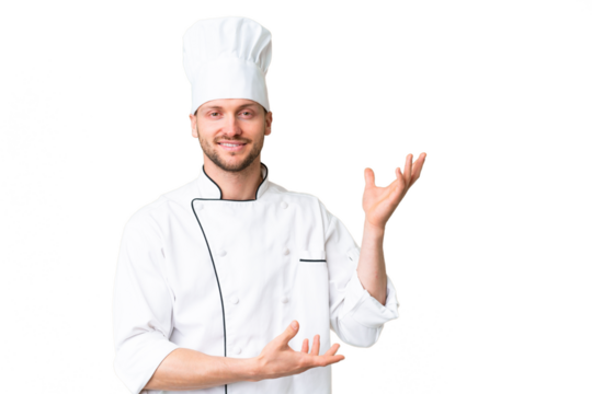 Young caucasian chef over isolated chroma key background extending hands to the side for inviting to come