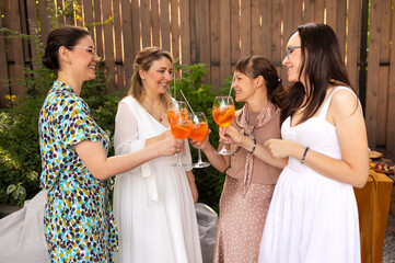 Happy female friends spending time together, young woman drinking Aperol spritz