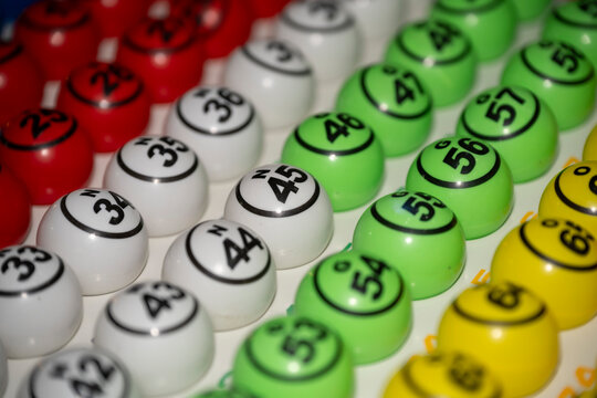Boules de loto en plastique multicolore num&eacute;rot&eacute;es sur leur plateau de tirage