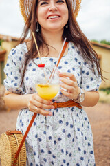 Close up of female hands holding glasses of acohol cocktail with fresh fruts and berries