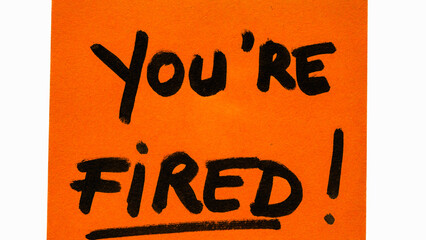 You are fired handwriting text close up isolated on orange paper with copy space.