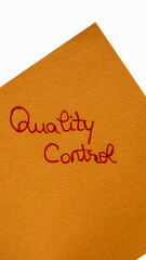 Quality control  handwriting text close up isolated on orange paper with copy space.