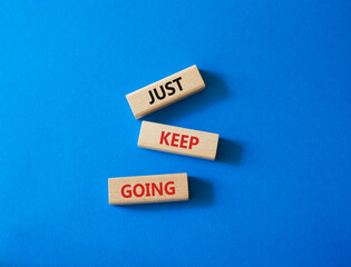 Just keep going symbol. Concept words Just keep going on wooden blocks. Beautiful blue background. Business and Just keep going concept. Copy space.