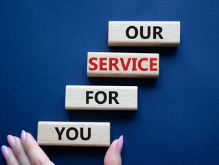 Our service for you symbol. Wooden blocks with words Our service for you. Beautiful deep blue background. Businessman hand. Business and Our service for you concept. Copy space.