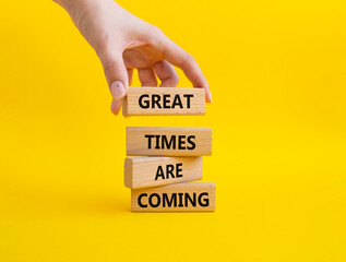 Great times are coming symbol. Concept words Great times are coming on wooden blocks. Businessman hand. Beautiful yellow background. Business and Great times are coming concept. Copy space.