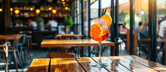 Aperol spritz cocktail on wooden table in cafe - Powered by Adobe