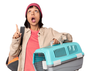 Young Hispanic woman ready for travel with pet carrier shrugs shoulders and open eyes confused.