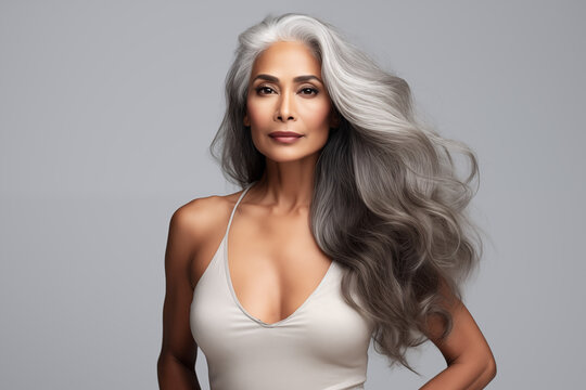 Gorgeous senior older Indian woman with pumped lips and long silver hair looking at camera