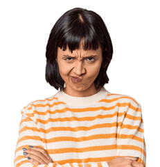 Young Hispanic woman with short black hair in studio frowning face in displeasure, keeps arms folded.