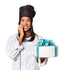Young Filipina chef presenting freshly baked cake biting fingernails, nervous and very anxious.
