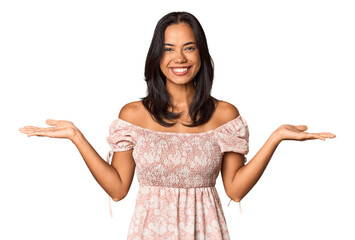 Young Filipina with long black hair in studio makes scale with arms, feels happy and confident.
