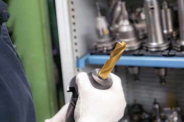 Metal-cutting cutters for a CNC machine in the hands of a worker to select tools.