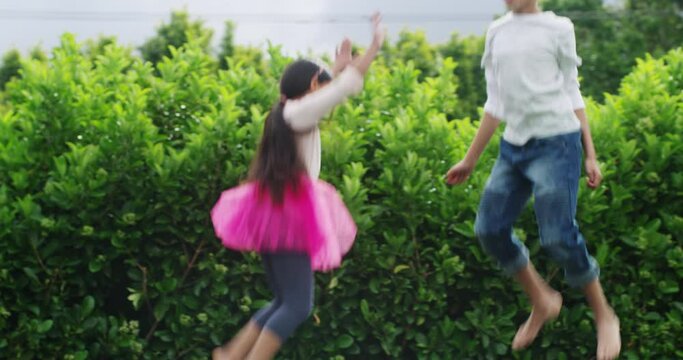 Jump, fun and children on a trampoline in the garden of their home together for sibling bonding. Family, brother and sister in the backyard to bounce while playing as kids during summer break