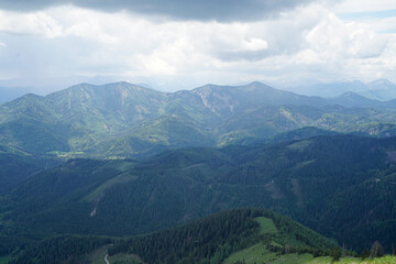 Fototapeta premium Idyllic panoramic view: Small green hills and steep snowy mountains in Ötscherland, Lower Austria