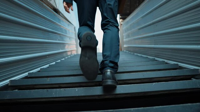 Closeup of successful business man leg walking up to stair. Manager changing workplace, discover a new thing, growth or getting promotion or walking in to light. Rising up. Focus on leg. Exultant.