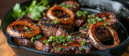 Filipino dry aged angus bistek tagalog steak with onion rings in soy sauce, served in a cast-iron casserole. - obrazy, fototapety, plakaty