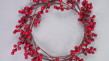Colorful background with strips of red berry garland on grey. Festive Christmas birthday decoration...