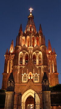 The fascinating front facade of the church/cathedral Parroquia de San Miguel Arcangel in San Miguel de Allende at night, Mexico