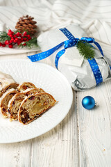 Christmas stollen on plate on white wooden table