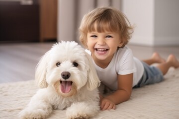 Kind mit Hund Zuhause auf Teppich, Kind trägt weißes T-Shirt und blaue Shorts, cremefarbener Teppich - obrazy, fototapety, plakaty