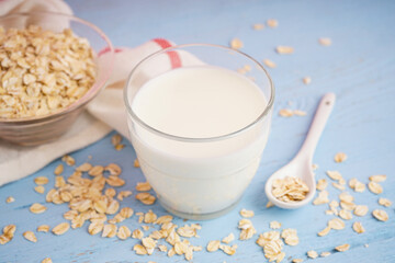 Glass of fresh milk on light blue wooden table background