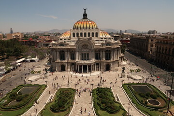 The beautiful Palacio de Bellas Artes/Palace of Fine Arts and the square and flower beds in front of it on a busy day, Mexico City - obrazy, fototapety, plakaty
