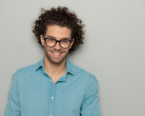 portrait of happy young man with glasses looking forward and smiling