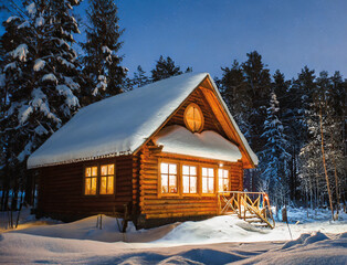 Krajobraz w zimowej, nocnej scenerii. Stary dom w zaśnieżonym lesie