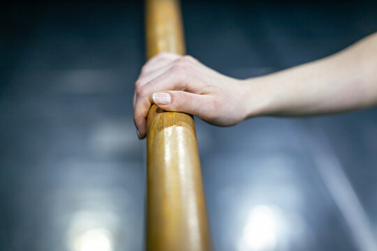 ballerina's hand resting on ballet barre - Powered by Adobe
