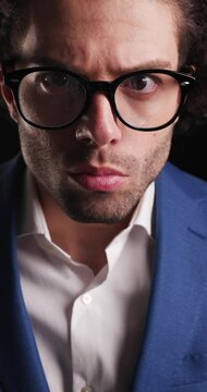 close up video of sexy curly hair man looking forward in an insistent way before walking away on black background
