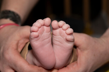 petits pieds de bébé dans les mains de sa mère
