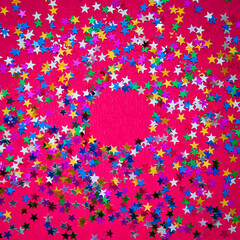 Round glitter frame on red background with copy space. Layout. Multi-colored stars.