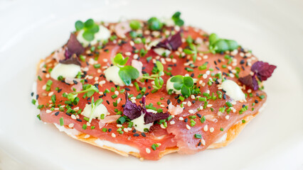 Close up of tuna sashimi on filo pastry on a white background
