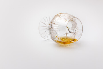 Overturned luxury glass with rum on a white background