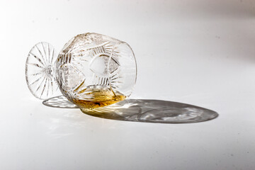 Overturned luxury glass with rum on a white background