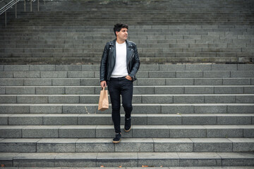 Obraz premium dark-haired boy in leather jacket going down stairs