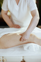 Obraz na płótnie Canvas Closeup on medical massage therapist massaging clients leg