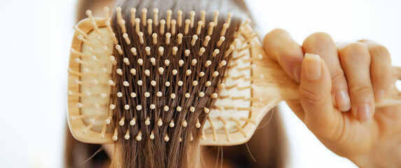 Closeup on young woman combing hair