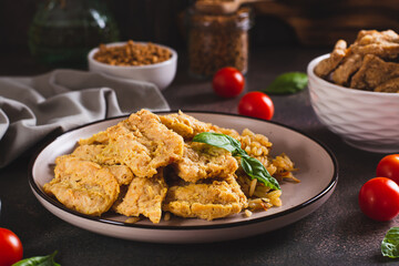 Vegetarian dish stew soy steaks with rice on a plate on the table