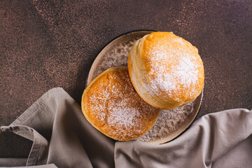 Close up of sweet donuts with powdered sugar filled with boiled condensed milk top view - obrazy, fototapety, plakaty
