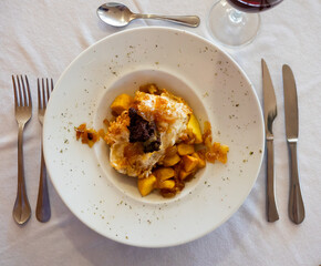 Spanish Huevos rotos con morcilla with eggs, potatoes, blood sausage and caramelized onions
