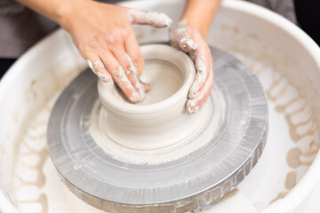 potter's wheel rotates and master creates future work of pottery from clay