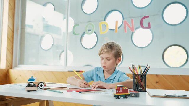 Smiling happy boy coloring creative picture and study in art lesson. Cute caucasian child excited or enjoy to learning coloring color book in online test Creative learning education. Erudition.