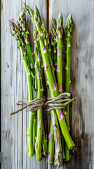 Fototapeta premium Fresh green asparagus bundle on rustic wood, farm-to-table, healthy eating.