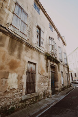 Old abandoned building facade in a narrow street old town Narbonne, France