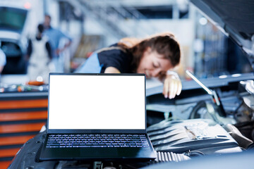 Mockup laptop next to repairman changing old car brake fluid with new one in repair shop. Isolated...