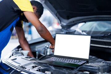Mockup laptop on car with hood open while BIPOC repairman in blurry background replaces brakes....