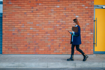 Caucasian Businesswoman walking in the Urban Landscape, Tackling Challenges with Her Smartphone.